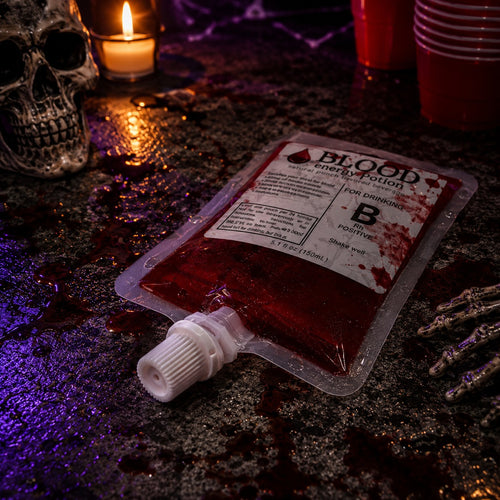 Mein Shop 6 Blutbeutel Trinkbeutel mit rotem Energy-Getränk für Halloween-Partys auf einem Tisch mit Totenkopf