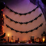 Mein Shop 6 Fledermaus-Girlande aus schwarzem Glitzerpapier als Halloween-Dekoration über einem festlichen Tisch